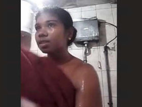 A dark-skinned Sri Lankan woman takes a bath