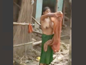 Indian wife bathes outdoors