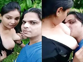 Sucks a girl's tits outdoors on camera for selfies